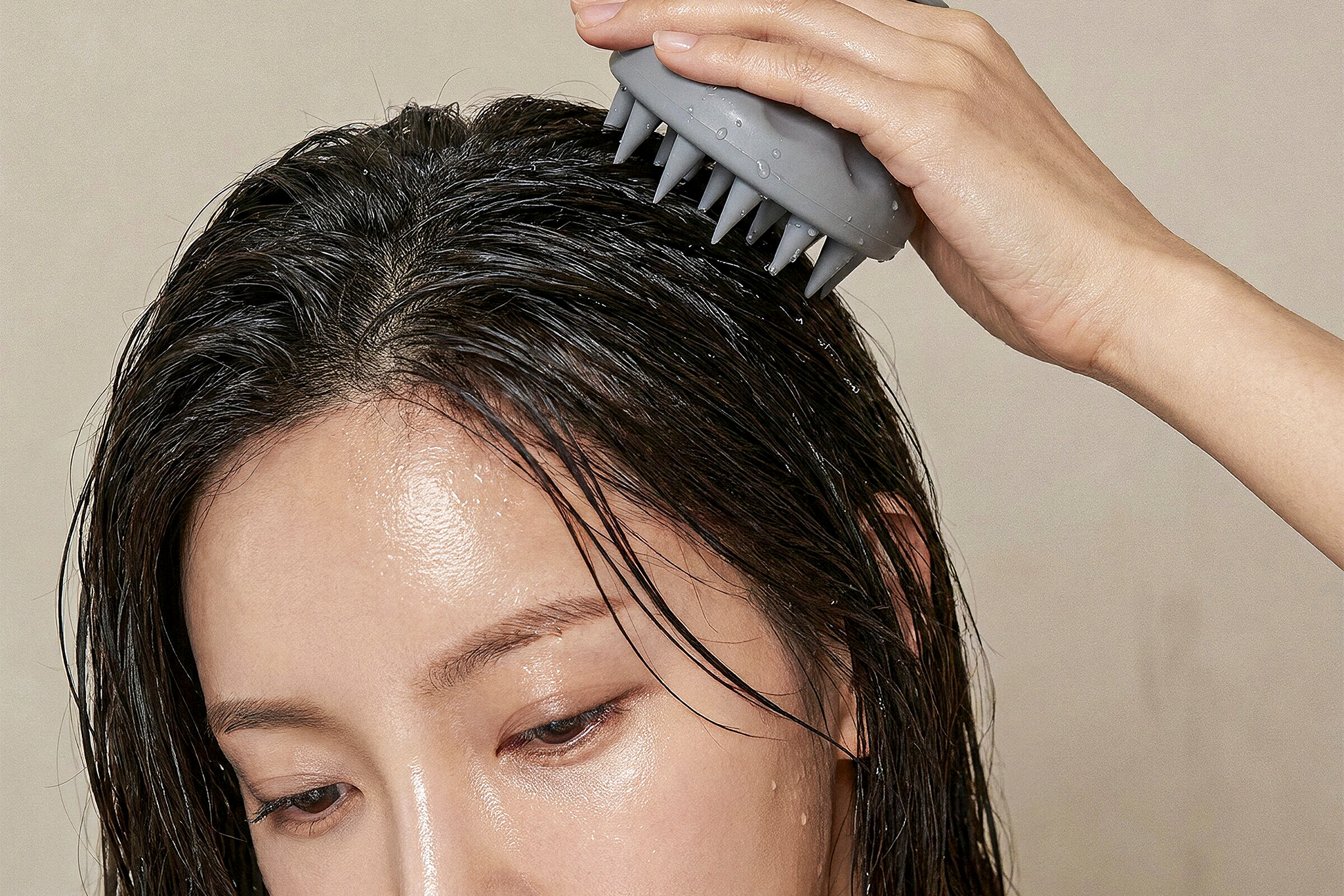 Model scrubbing her scalp representing scalp care treatments in Seoul